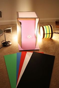 there are many different colored papers on the floor next to a lamp and some lights