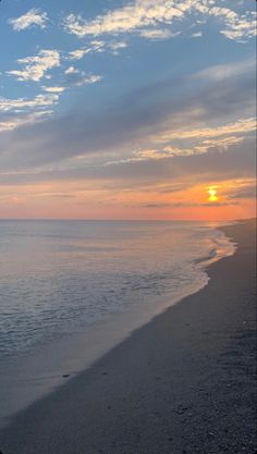 the sun is setting over the water at the beach