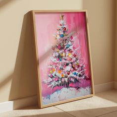 a painting of a colorful christmas tree on a pink background in a room with light coming through the window