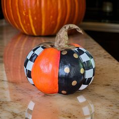 an orange and black pumpkin sitting on top of a counter