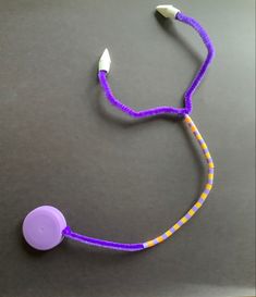 a purple and yellow cord attached to a white toothbrush on top of a table