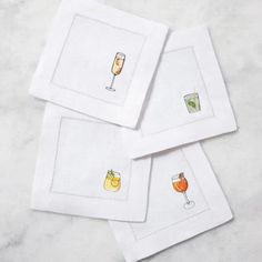 four white napkins with drinks on them