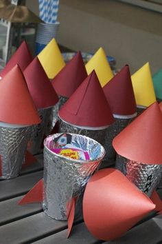 several cones are lined up in tins on top of a table with candy wrappers