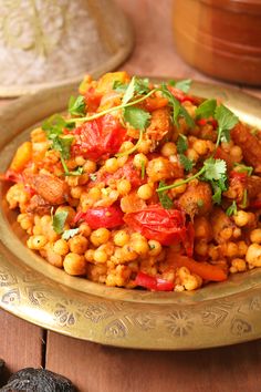 a gold plate topped with chickpeas and tomatoes