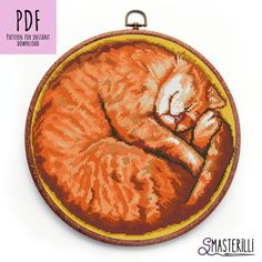 an orange cat cross stitched in to a round frame