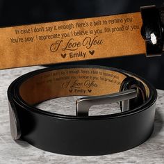 a leather belt with the words i love you engraved on it and a wooden box