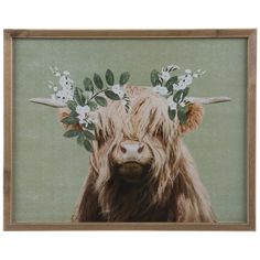 a cow with flowers on its head is shown in a wooden box frame, against a green background