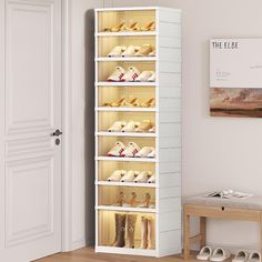 a white shoe rack filled with shoes next to a wooden table and chair in a room