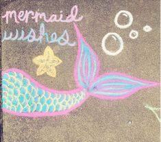 a chalk drawing of a mermaid with bubbles and starfish on the sidewalk next to it