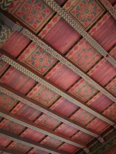 the ceiling is covered with red and green paint, which has intricate designs on it