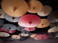 many different colored umbrellas hanging from the ceiling