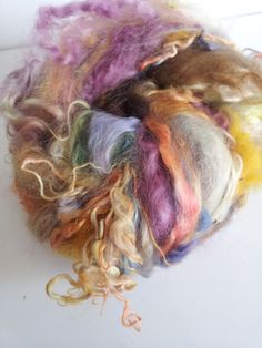 a pile of multicolored wool sitting on top of a white table