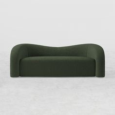 a green couch sitting on top of a cement floor