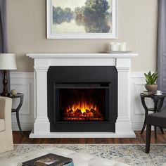 a living room with a fire place in the center and a painting on the wall