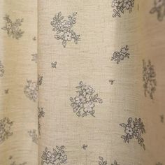 a close up view of a curtain with flowers on it and the fabric has been pulled back