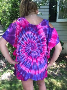 "This color combination poncho is new to my store just now, Summer 2016. This shirt is so neat, so pretty and can even be used as a bathing suit cover up. This is my beautiful niece modeling it. Some may call it a poncho. It is a 100% rayon lightweight, discreet exposed shoulder (peek a boo) shirt. What an incredible shirt for hot summer nights or anytime for that matter. Wear with leggings or even jeans; it will look fantastic. This particular shirt, I dyed in lilac, purple, hot pink and dragon Multicolor Bohemian T-shirt For Beach, Multicolor Bohemian T-shirt For The Beach, Bohemian Multicolor T-shirt For Beach, Tie Dye Short Sleeve Top For Summer, Spring Festival Hippie T-shirt, Bohemian Multicolor T-shirt For Vacation, Fun Summer Festival T-shirt, Oversized Purple T-shirt For Summer, Trendy Purple Summer Blouse