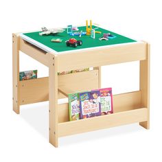 a child's wooden table with toy cars and blocks on the green top, set against a white background