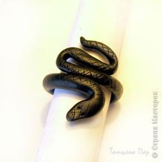 a black snake curled up on top of a white paper