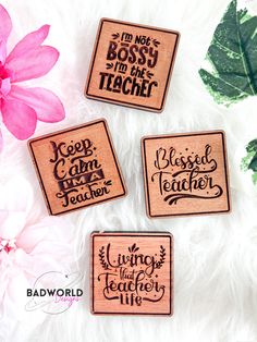 three wooden magnets with words on them and flowers in front of white furnishing