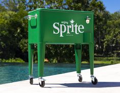 a green cooler sitting next to a pool