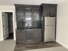 an empty kitchen with gray cabinets and wood flooring