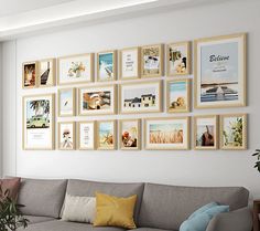 a living room filled with lots of framed pictures on the wall next to a couch