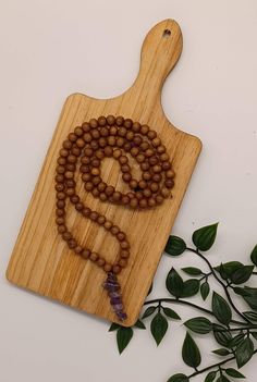 Made with beautiful natural Tulsi beads ( hand sourced from India) and finished with a stunning Amethyst centre piece. It has the natural fragrance of tulsi, with traditional knots between each bead.  Tulsi ( sacred basil) is one of the purest types of wood used in Indian worship. Tulsi is supposed to possess remarkable physical and spiritual healing properties. It also helps to improve devotion and love to the heart. This can be used as a meditation necklace or as Jaap (prayer) beads.  Necklace Spiritual Wooden Beads Jewelry For Healing, Holistic Hand-strung Healing Mala, Spiritual Necklace With 108 Natural Beads, Spiritual Natural Jewelry For Meditation, Holistic Healing Mala With Wooden Beads, Natural Spiritual Jewelry For Meditation, Holistic Hand-strung Mala As Gift, Spiritual Lavender Jewelry With 8mm Beads, Lavender Spiritual Jewelry With 8mm Beads