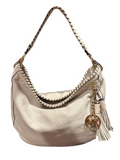 This function-with-style hobo handbag by KORS Michael Kors is crafted from off-white leather. The flat handle is wrapped in leather to match the wrapped opening. Gold tone hardware with logo zipper tabs and the MK dangling logo charm next to a fun duo of leather tassels.  The interior is lined with fabric and features three slip pockets. Condition  One tassel shows a minor mark. See last photo Designer Everyday Hobo Bag With Zipper Closure, Designer Everyday Hobo Bag With Zipper, Everyday Designer Hobo Bag With Zipper Closure, Designer Hobo Bag With Zipper For Everyday, Luxury White Hobo Bag With Leather Handles, Luxury Cream Soft Leather Hobo Bag, Beige Leather Hobo Bag With Handle Drop, Luxury Cream Hobo Bag With Handle Drop, Designer Beige Leather Hobo Bag