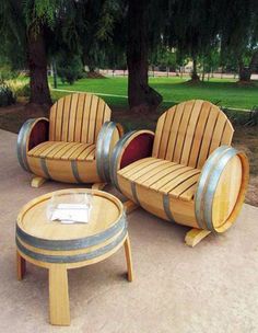 three wooden chairs sitting next to each other with barrels around them on top of cement