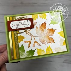 a hand holding up a card with leaves on it and the words grateful written on it