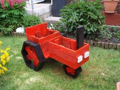 a wooden toy truck sitting in the grass