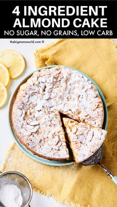 a cake on a plate with one slice cut out and some lemons in the background