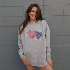 This precious crewneck is sure to be the cutest piece for your summer wardrobe. This oversized fit crewneck will have three patchwork hearts in blue & red shades, with your sorority name embroidered in script next to the hearts. Fully embroidered design, all crews will have the same fabric & pattern order. This crewneck is an oversized, relaxed fit. The model is a size 4, wearing a size medium. Order your normal size for an oversized fit, but a size down if you want it to fit closer to a classic unisex crew. Bulk order pricing available, reach out to us via email info@thelettermarket.com to get started on a custom order! SIZE CHART: Sorority Sweatshirt Design Cricut, Embroidered Sorority Shirt, Sorority Patchwork Shirt, Sorority Embroidered Sweatshirt, Embroidered Crewneck Diy, Patchwork Crewneck, Stitched Sweatshirt, Stitch Sweatshirt, Patchwork Ideas