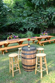 an outdoor picnic with wooden tables and stools