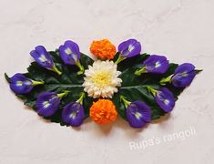 an arrangement of flowers arranged on a white surface