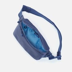 an empty blue purse on a white surface with the strap down to it's side