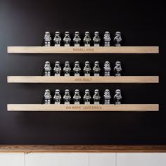 star wars themed legos are lined up on wooden shelves in a black and white room