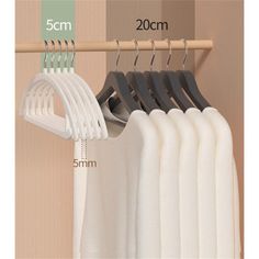 the measurements of clothes hanging on a rail and in front of a wall with two hangers