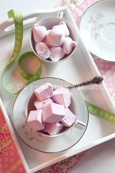 two bowls filled with marshmallows sitting on top of a table next to a plate