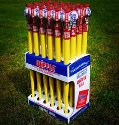 a bunch of yellow toothbrushes are in a display case on the green grass