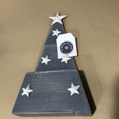 a wooden christmas tree with white stars on it