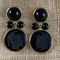 From Italy, A Pair Of 14-Karat Gold Framed Earrings With Black Onyx Cabochons, Beads, And Carved Classical Roman Armorial Intaglios. Circa Late 1970s - Early 1980s. Posted With Backs. The Upper Bezels Hold Flat Back Cabochon Cut, Domed Onyx Stones, Terminating With Two Pinned And Capped Onyx Beads. The Pins Hold A Swinging, Bezeled Carved Onyx Stone, Each Showing A Different Roman Helmeted Warrior Head. Measures: 1 Inch Long (25.4 Mm) X .75 Inch Wide (19.05 Mm) .50 Inches From Front To End Of Post. Intaglios: .50 Inches Diameter (12.7 Mm) Top Stone - 6.35 Mm Beads - 3.175 Mm. Excellent Vintage Condition. Roman Jewelry, Onyx Bead, Onyx Stone, Vintage Italian, Gold Frame, Black Onyx, Onyx, Jewelry Earrings, Women Jewelry