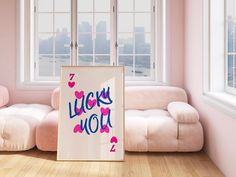 a living room with pink walls and white furniture, including a large framed sign that says lucky wolf