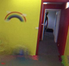 an open door with a rainbow painted on the wall and a person standing in the doorway