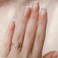 a woman's hand with a ring on it and two different nail polish colors