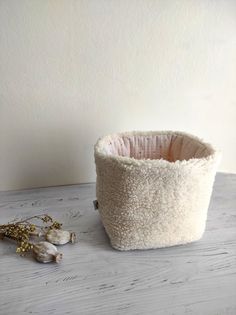 a white basket sitting on top of a wooden table