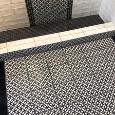 a black and white tiled bathroom with an open shower