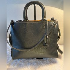 Gorgeous Coach Rogue 1941 Gvn Pbb 224221jax Glovetanned Pebble Leather In Black With Beautiful Pewter Hardwear And Suede Interior. 12 1/4”W X 9 3/4” H X 5 1-2” W. Handles Have A 3 1/2” Drop. Detachable Straps With 10” Drop For Shoulder Wear Or Can Be Linked Together For Crossbody Wear. Inside Zip Pocket And French Purse Pocket. This Bag Has Been Used Twice And Is In Practically Brand New Condition. Comes With Dust Cover And Box. Luxury Bag With Gunmetal Hardware And Pebbled Leather, Black Pebbled Leather Bag With Gunmetal Hardware, Black Textured Leather Satchel For Fall, Black Pebbled Leather Bag With Palladium Hardware, Coach Black Satchel For Fall, Coach Leather Satchel For Fall, Black Bags With Branded Hardware For Fall, Black Pebbled Leather Satchel For Work, Black Coach Satchel For Fall