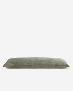 a green pillow sitting on top of a white wall