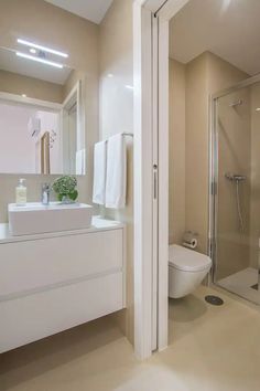 a bathroom with a sink, toilet and shower stall in the middle of it's walls